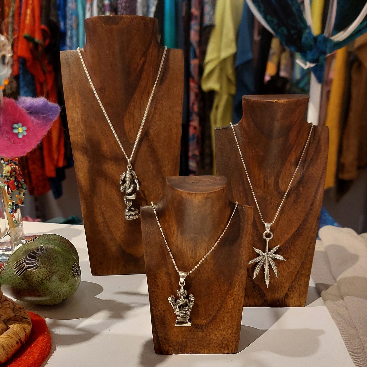a group of necklaces sitting on top of a wooden stand